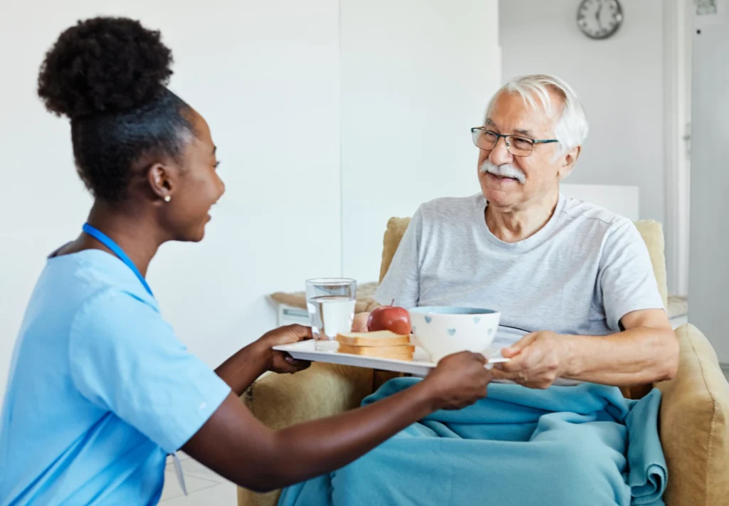 caregiver and man food on tray