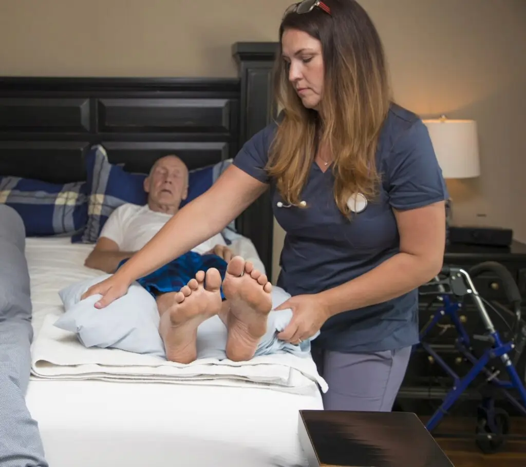 24 hour care assisting man on bed