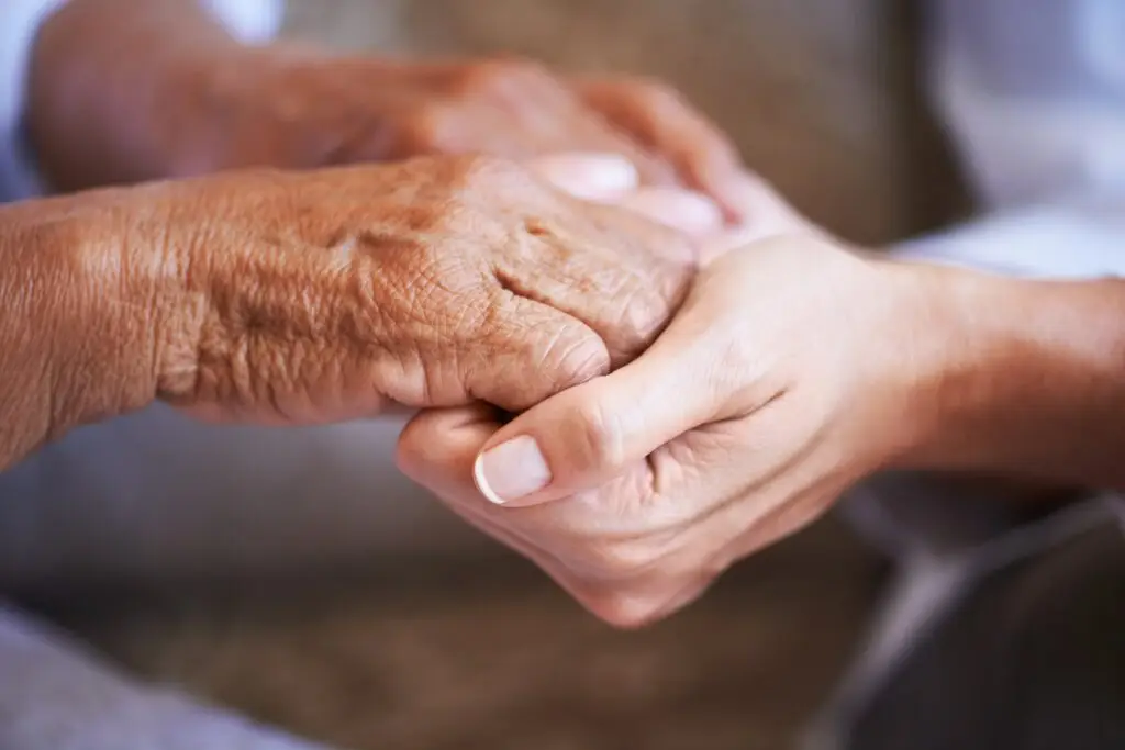 caregiver holding elderly client's hands