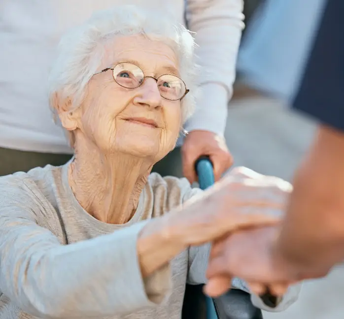 elderly woman looking up at caregiver in alumni home care polo