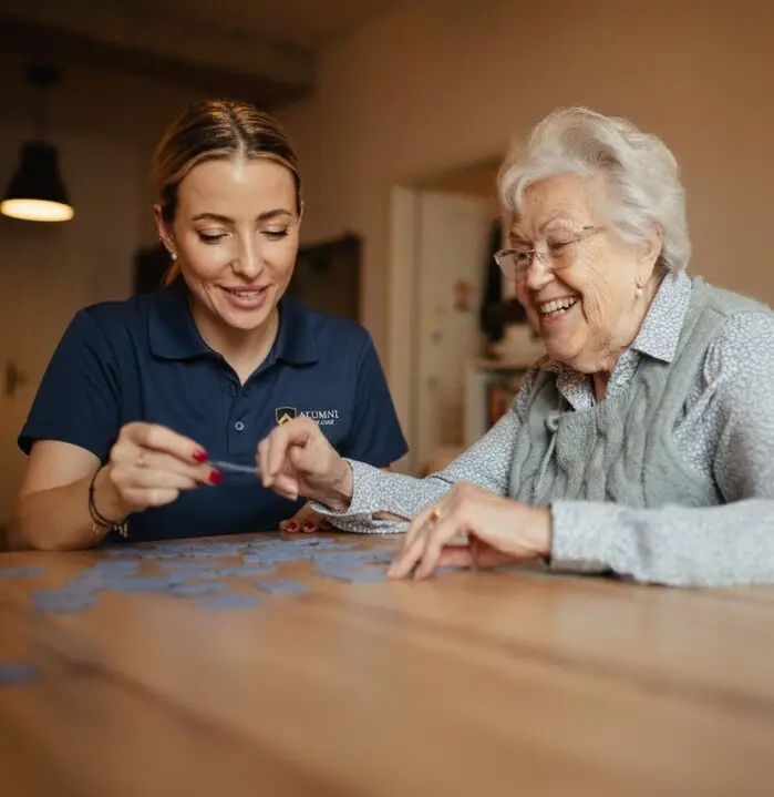 alumni home care caregiver doing puzzle with dementia patient
